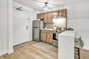 a kitchen with wooden cabinets and stainless steel appliances at The Meriden, Meriden, 06450